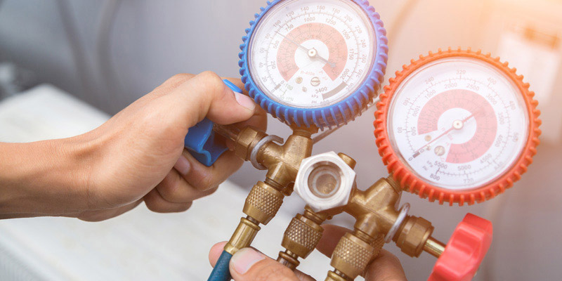 ac technician holding hvac gauges