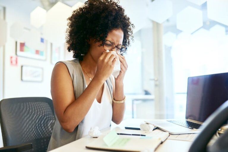 young woman sneezing min